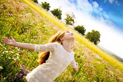 fille qui etend les bras dans un champ de fleurs