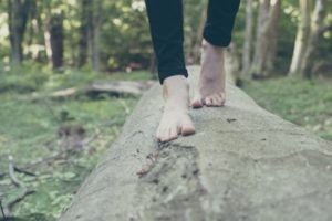 pied d humain marchant sur un tronc d arbre